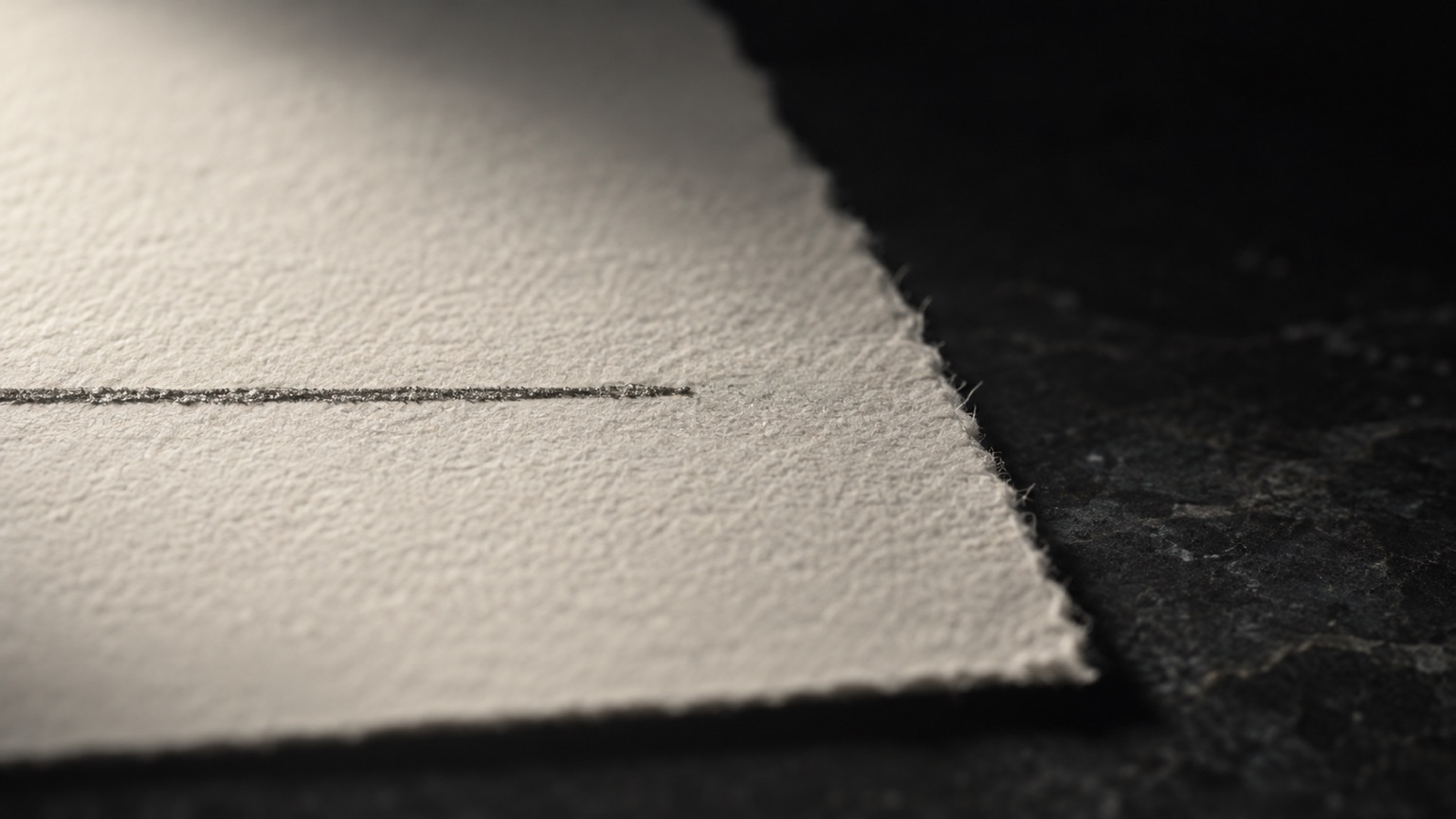 A single pencil line drawn across cream cotton paper